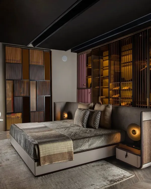 The ISOLA bedroom collection is designed around the concept of placing the bed as a central island. Here, the upholstered bed is backed by a bespoke wardrobe system featuring tinted glass and metal profiles.