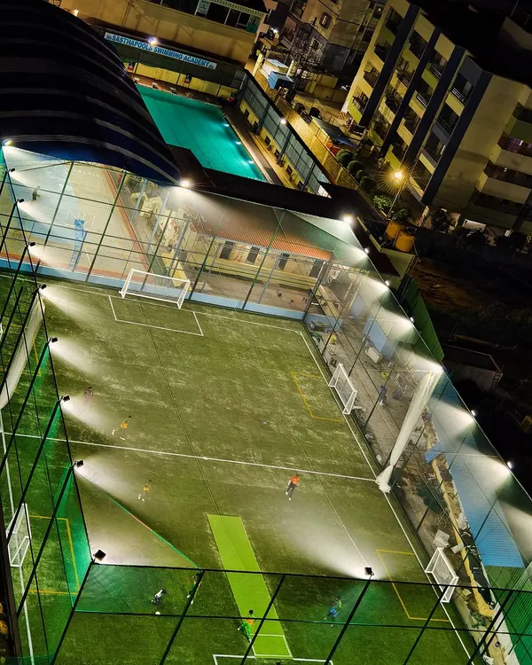 An aerial view of our state-of-the-art football turf, inaugurated and ready for action under the bright floodlights for evening and night matches.