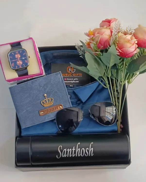 This complete gift hamper in a blue theme includes a personalized wallet, a name-engraved temperature bottle, a watch, sunglasses, and a shirt, all beautifully presented with a floral touch.