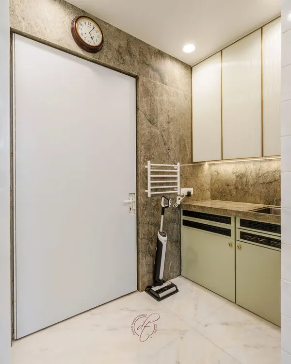 This utility area is designed for maximum efficiency. It features a dedicated sink, a wall-mounted drying rack, and seamless cabinetry, all set against a durable, textured wall finish.