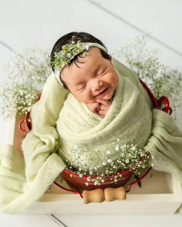 This blissful smile is what makes my heart melt. I love creating these serene floral setups, where your baby can dream peacefully surrounded by soft textures and delicate baby's breath.