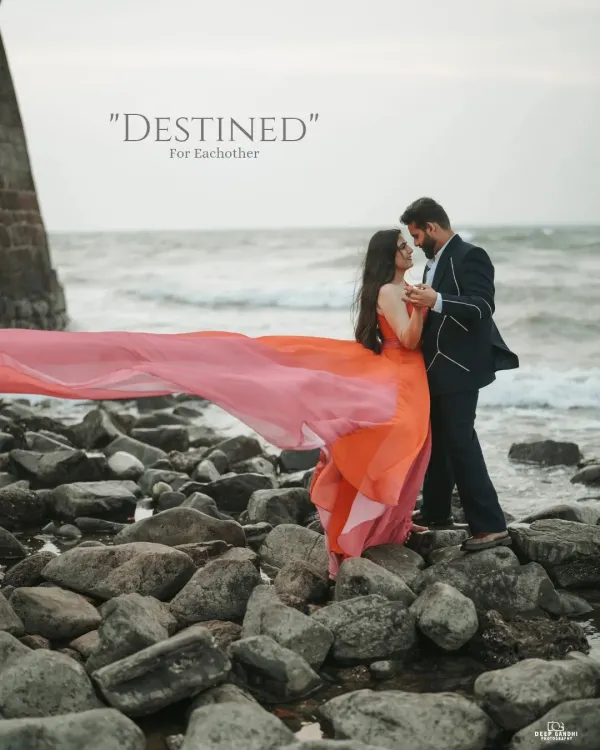 A beautiful shot on a rocky Goa beach, with the bride's flowing gown catching the wind as the couple shares a dance, perfectly capturing a "destined for each other" moment.