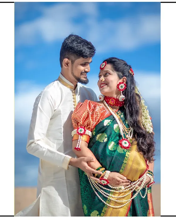 This couple looks stunning in their traditional attire. The mom-to-be is wearing a beautiful green saree with floral jewelry, and her partner is in a classic white kurta.