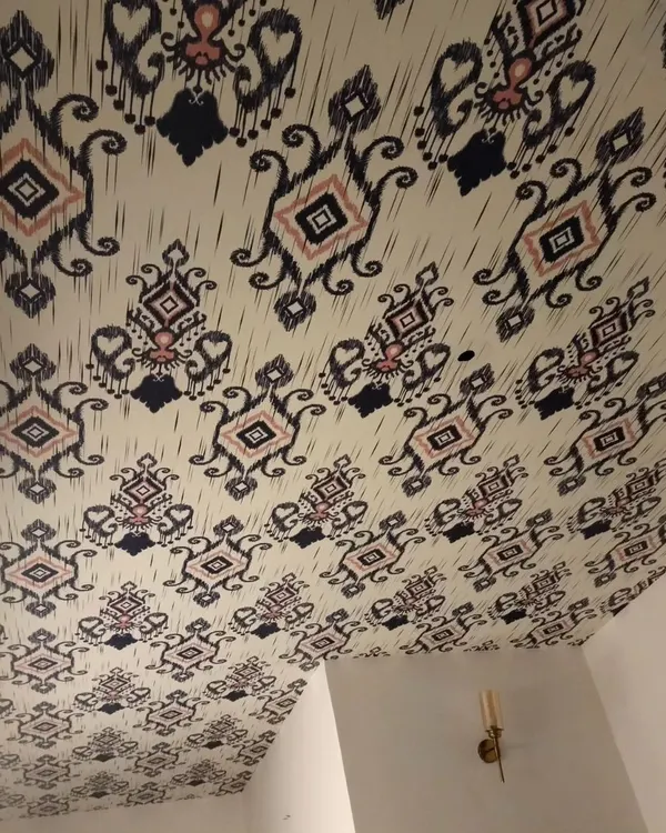 An example of a ceiling wallpaper installation. This traditional ikat pattern adds an unexpected and stylish element to the room.