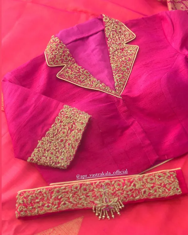 A modern take on the traditional blouse. This pink blouse features a notched collar design, with the lapels heavily embroidered in gold zardosi for a fusion look.