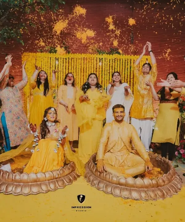 Celebrating each other with every prayer the haldi contains. A beautiful shot of the couple and their family showering them with flower petals.