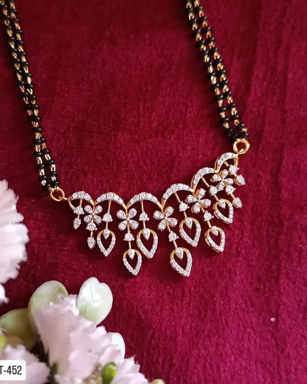 A modern take on the traditional mangalsutra, this piece is crafted from 92.5 silver with gold plating. It features a beautiful floral pendant made of American diamonds for a touch of sparkle.
