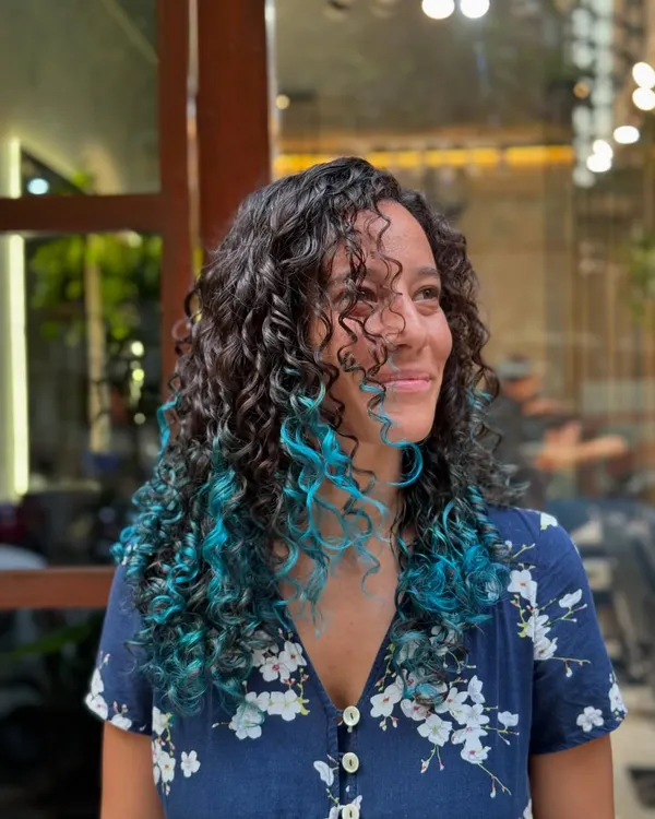 A peekaboo of bright turquoise adds an element of surprise and fun to these dark curls.