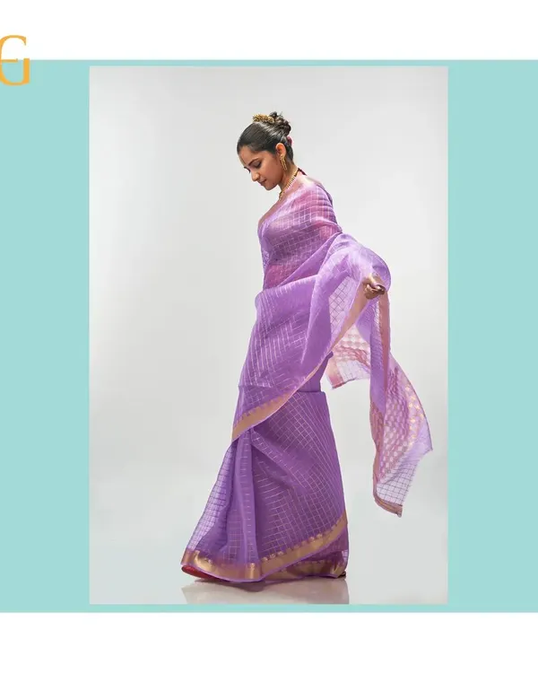 This ethereal African Violet silk organza saree feels almost weightless. The delicate gold zari checks catch the light beautifully, creating a subtle shimmer with every movement.