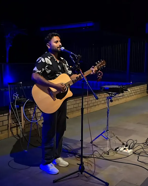 Performing a solo acoustic set at an outdoor venue. The blue uplighting created a cool and relaxed vibe for the evening.
