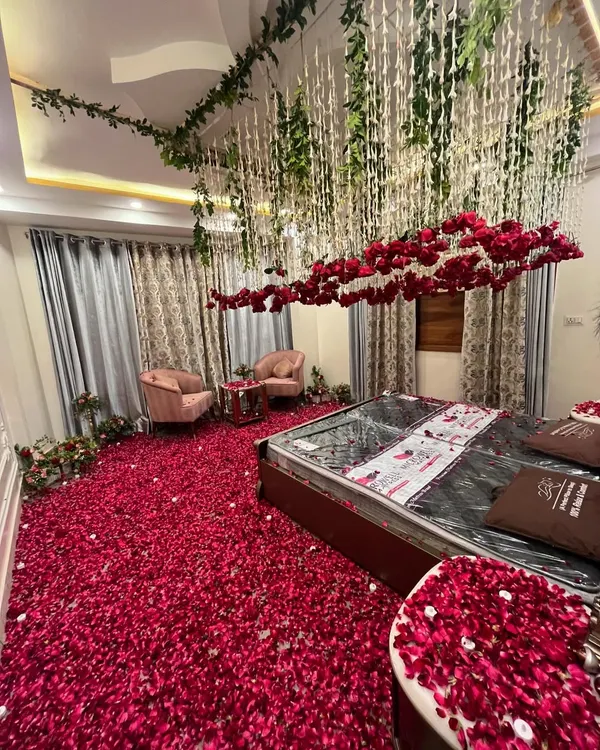 A wide view of a room transformed with a ceiling floral installation. I used hanging green vines and floral strings to create a magical canopy effect over the entire space.