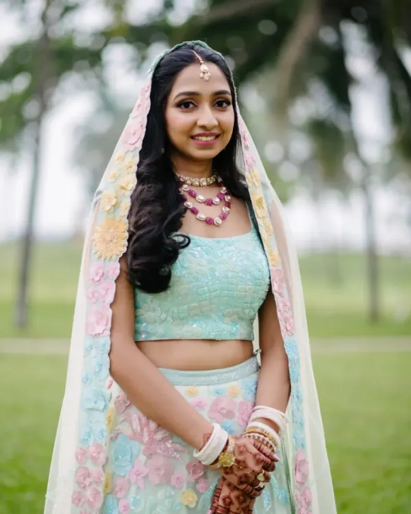 A radiant close-up portrait of the bride in her pastel lehenga, smiling beautifully against a soft, natural background in Goa.
