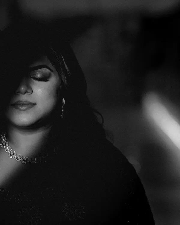 A dramatic black and white portrait of the bride, with light and shadow playing across her face. This artistic shot is full of emotion and mystery.