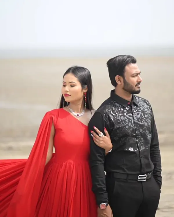 This classic red gown with a single dramatic sleeve is paired perfectly with a black patterned shirt for the groom-to-be. A timeless look for a pre-wedding shoot.