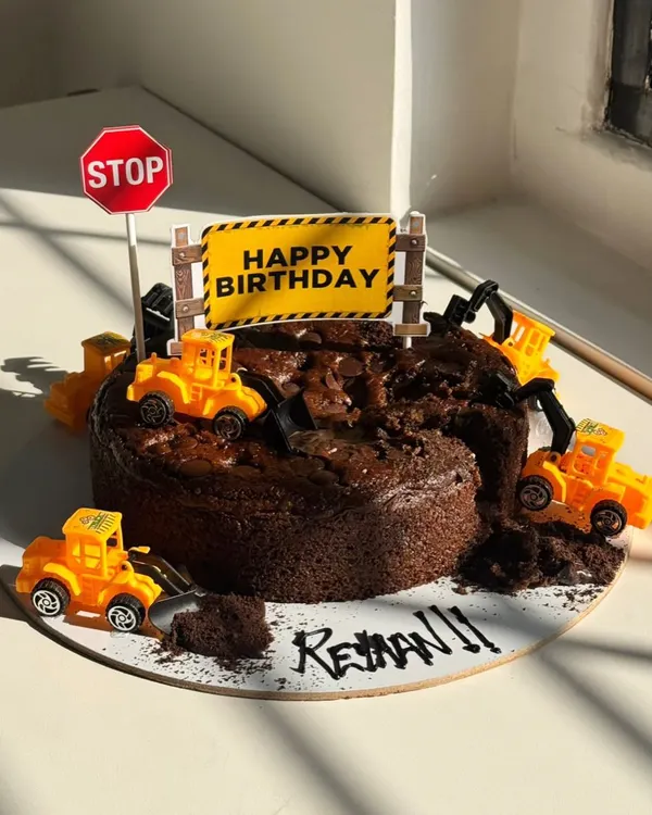 For Rehan's birthday, we created this fun "under construction" themed chocolate cake. Complete with tiny toy bulldozers and a stop sign, it’s a playful design that turns a favorite interest into a delicious celebration.