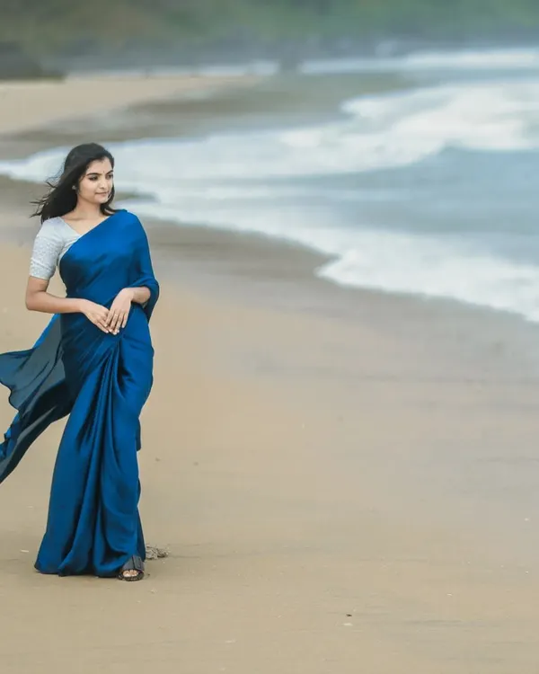 A stunning outdoor photoshoot by the sea. I created a very natural, wind-proof makeup look and a simple, flowing hairstyle to match the elegant blue saree and the beach setting.