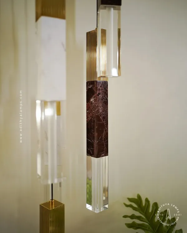A collection of our pillar pendants, which combine sections of solid marble, fluted metal, and clear crystal. These substantial, high-quality fixtures can be hung individually or in clusters to create a dramatic effect in stairwells or entryways.