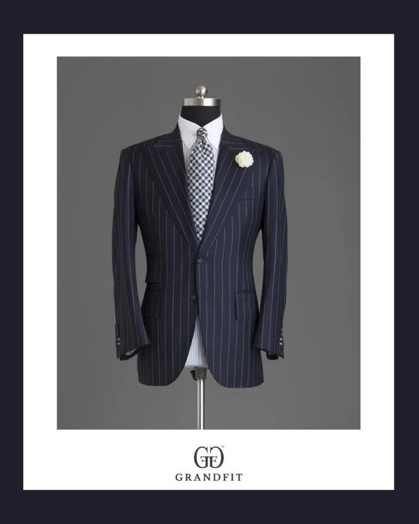 A classic navy pinstripe suit jacket, defined by its sharp tailoring and accessorized with a lapel flower for a touch of celebratory flair.