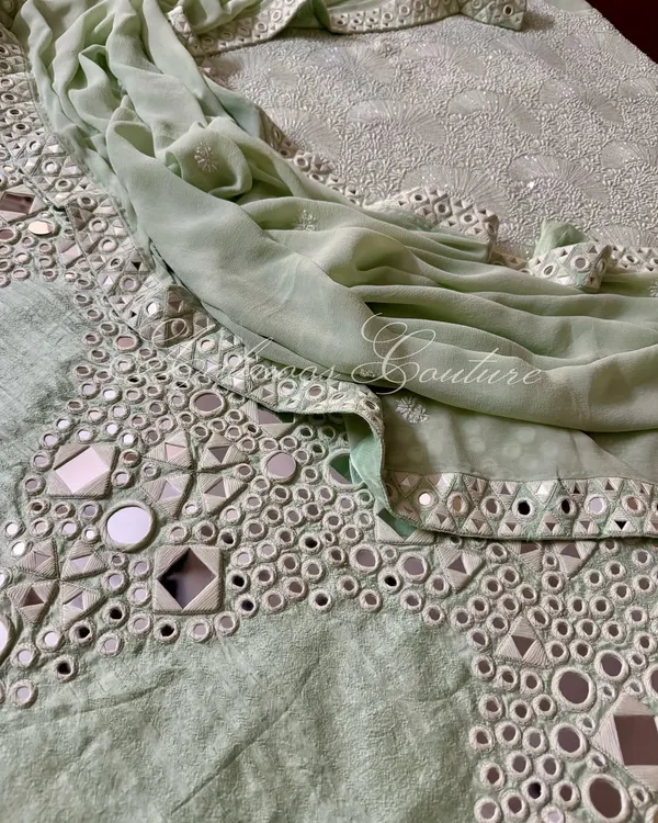 A stunning example of Kutchi hand mirrorwork on our mint green pure raw silk palazzo. The geometric arrangement of mirrors creates a dazzling effect, perfect for festive occasions.
