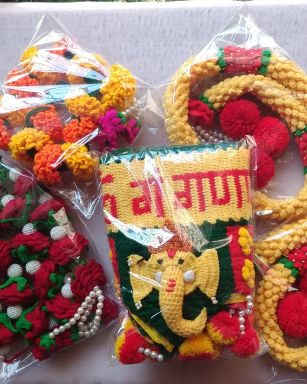 A dispatch photo showing a Ganpati Toran, Mogra latkan, Rose garland, and Marigold garland, all packed and ready to be sent to a customer.