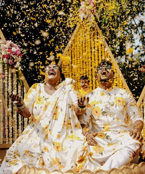 The moment the flower petal shower begins. This is the peak of the Haldi celebration, and capturing the couple's ecstatic reaction is priceless.