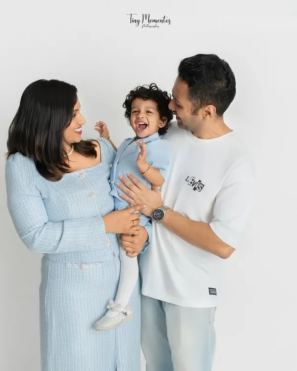 A frame filled with laughter and love. This family portrait captures a genuine moment of joy between parents and their little one.