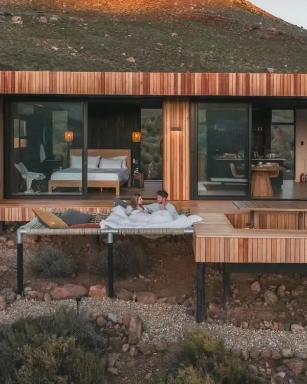 Imagine waking up to this. I design holiday homes that offer complete serenity, featuring unique elements like this deck hammock and an integrated hot tub for the ultimate relaxation experience.
