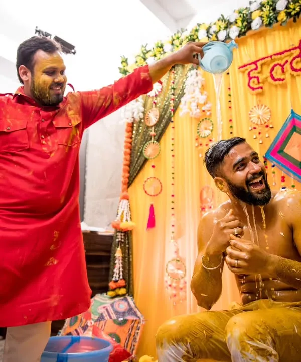 The quintessential Haldi moment. We capture the fun and chaos as friends and family douse the groom in water and turmeric paste.