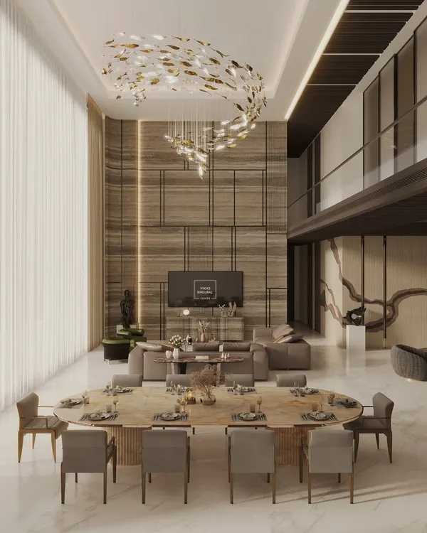 A glimpse into a double-height living and dining area we designed for a luxury penthouse in Mumbai. The space is defined by a dramatic sculptural chandelier, bespoke furnishings, and a mezzanine level, all curated to create an atmosphere of refined elegance.