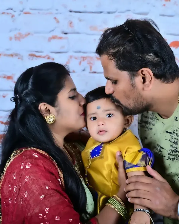 A close-up portrait showing the pure affection of parents for their baby. Dressed in traditional attire, this image highlights the tender moments that make family portraits so meaningful.