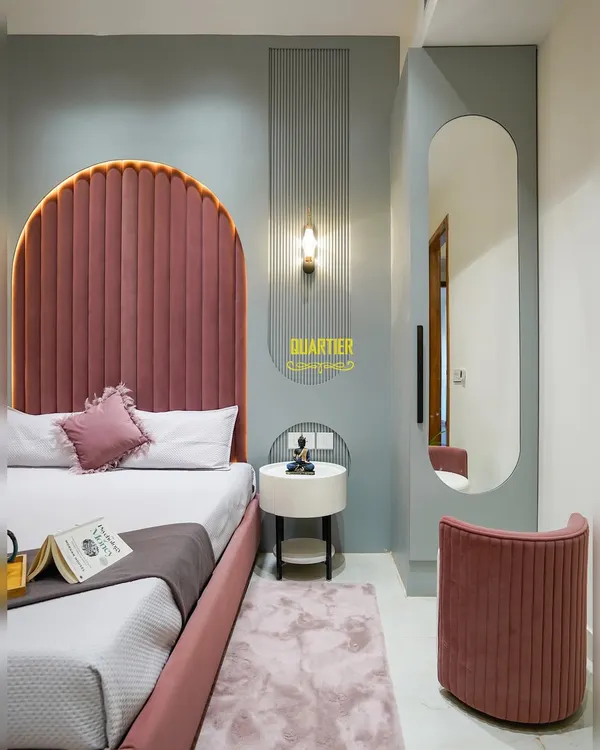 This daughter's bedroom at Apex D'Rio is a dream in pink and grey. The arched, tufted headboard is the star, complemented by a dedicated dressing area with a full-length mirror and a matching fluted stool.