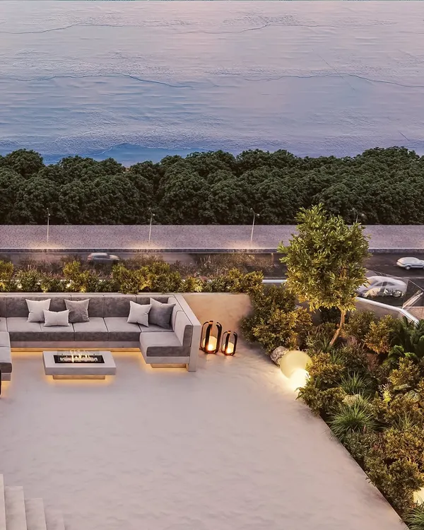 This private terrace opens up to the stunning Mumbai skyline and the sea beyond. The design features a comfortable, modern sectional sofa and a central fire pit, creating an inviting space for evening gatherings.