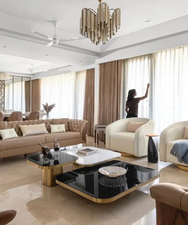 A wide shot of the Anand Niketan project, showcasing the harmonious blend of the living and dining areas under a cohesive, luxurious design scheme.
