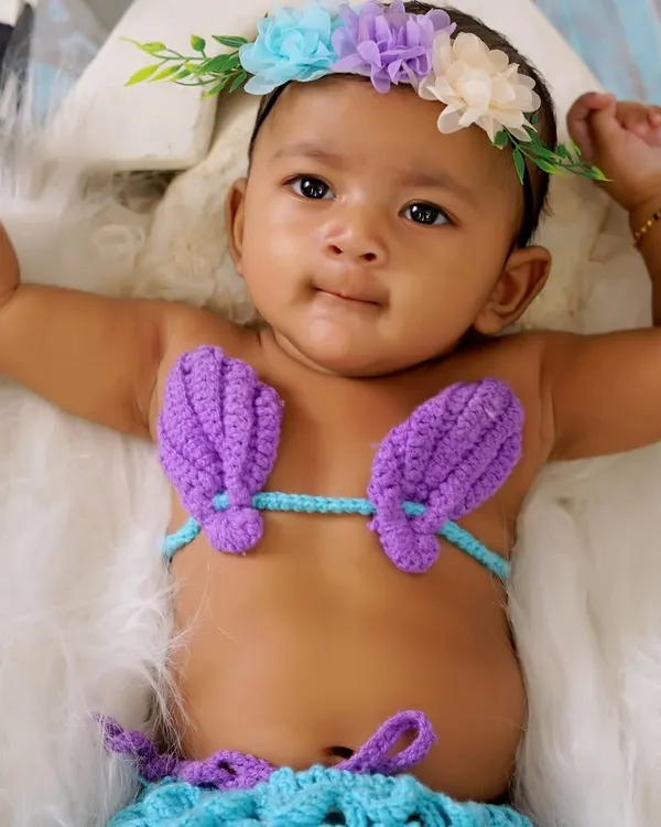 Our little mermaid theme is a favorite among parents. Here is a beautiful baby girl in a hand-knitted mermaid costume, complete with a floral headband.