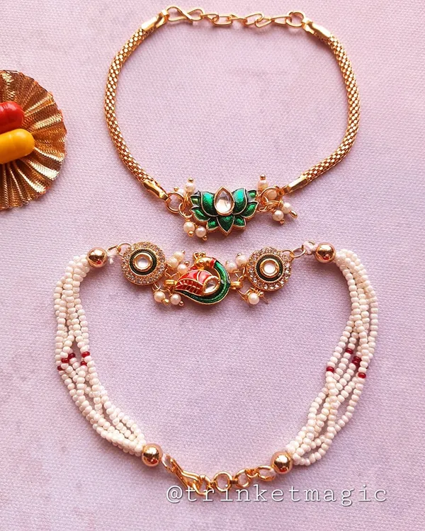 A beautiful Bhai Bhabhi Rakhi set featuring a peacock-inspired design for bhabhi and a matching lotus Rakhi for bhai. The pearl and beadwork make this a truly elegant choice.