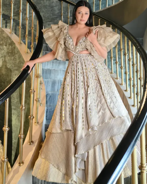 A full-length view of the stunning Kalki Fashion gown. The dramatic ruffled sleeves and intricate mirror work make it a true piece of art. Posing on this spiral staircase highlighted the gown's magnificent structure and flow.