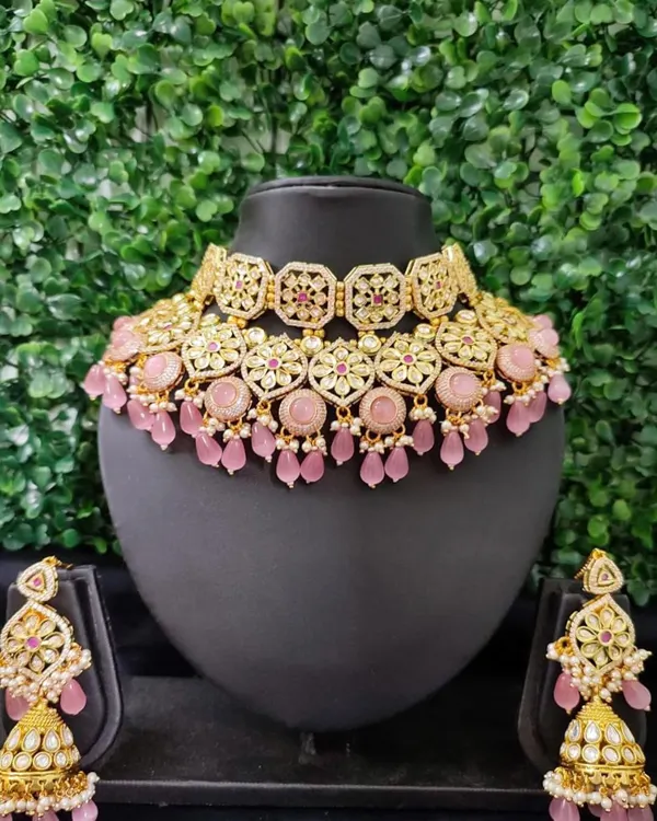 This pastel pink kundan set is a dream for a daytime wedding or a romantic-themed event. The set includes a choker, matching jhumkas, and a maang tikka.