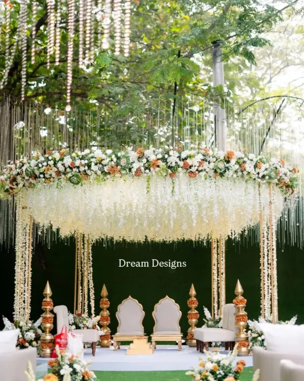 This is where your forever begins. I designed this breathtaking mandap with a canopy of cascading white florals and lush greenery, creating a space that feels both grand and intimately romantic for the wedding ceremony.