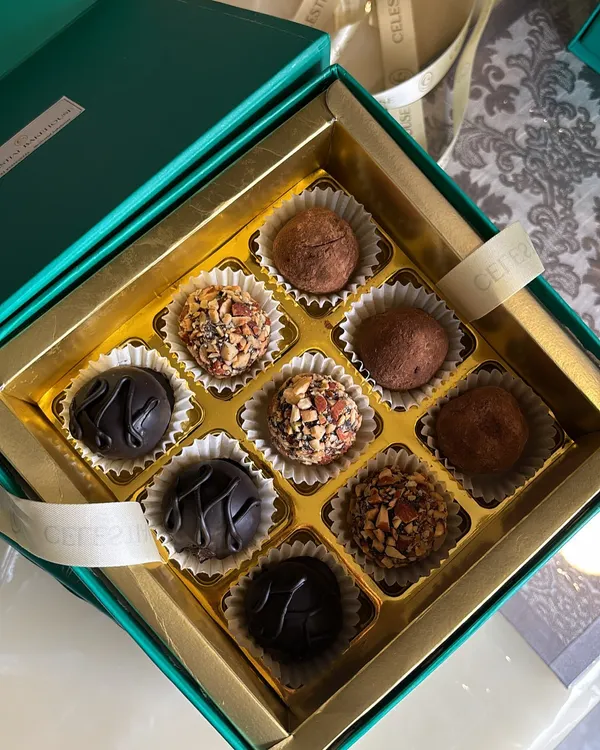 A close-up of our assorted chocolate truffle box. Each truffle is handcrafted with care, featuring flavors like classic dark chocolate, roasted almond, and more.