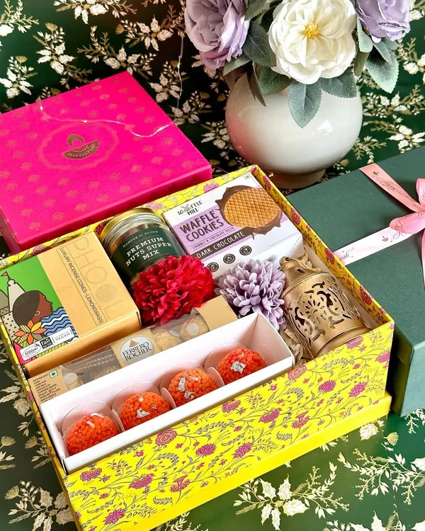 This vibrant yellow Diwali box is a feast for the senses. It's packed with Vahdam tea, Phool incense, waffle cookies, ladoo candles, Ferrero Rocher, a decorative lantern, and a jar of premium nuts, making it a complete festive celebration in a box.