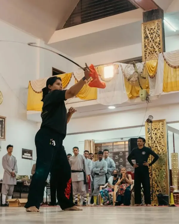 A dynamic action shot of me demonstrating a Wushu sword form. The sword requires precision, fluid movement, and a sharp focus, embodying the spirit of the warrior.