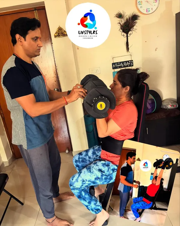 Personal guidance makes all the difference. Here, I'm assisting a client with proper form for a seated bicep curl on a bench, ensuring she engages the right muscles and avoids strain.