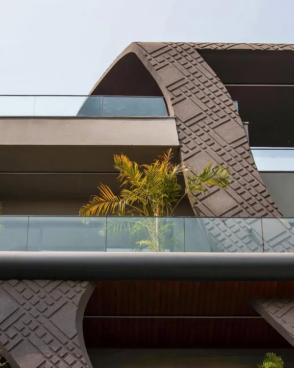 A close-up of the wave-form facade, showcasing the intricate concrete grooving work. This detail, inspired by fluid beauty, blends aesthetics and sustainability, creating a texture that plays with light and shadow.