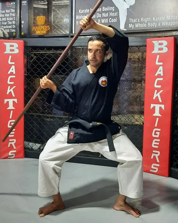 I demonstrate a fundamental stance with the six-foot Bo staff. Mastering this weapon requires deep focus on posture, balance, and precise movement, which are the cornerstones of my Okinawan Kobudo training.