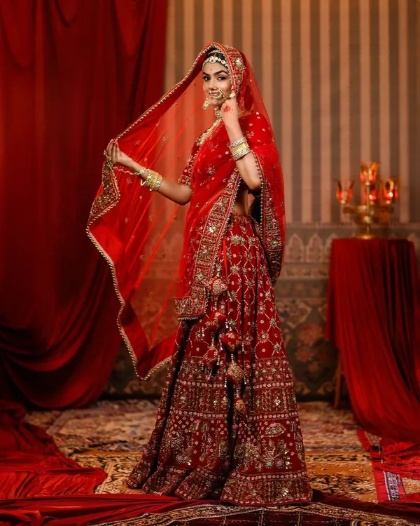 We bring the epic scale of Bollywood to your personal photoshoot. This full-length view of our Padmavati recreation showcases the magnificent, heavily embroidered red Rajputana lehenga, styled to perfection for a truly royal experience.