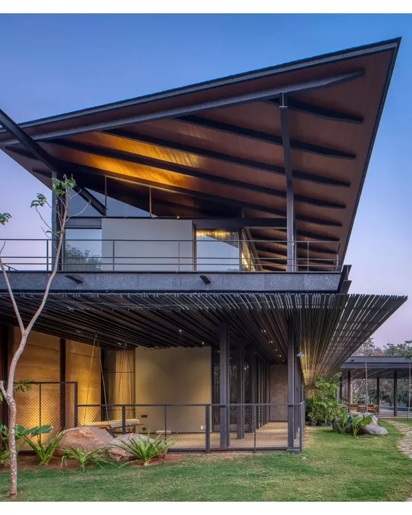Our Lakeshore house in Hyderabad, resting by the water as dusk settles. This home is a filter for breezes and views, built from the very earth of the site and a precise metal skeleton. It is a duet between the architecture and the landscape.