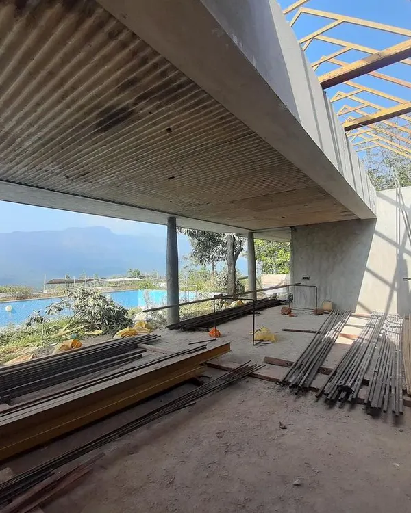 An under-construction view of a boutique hotel in Chikmagalur, where the concrete form is shaped to frame the breathtaking mountain vistas.