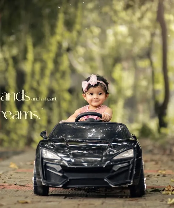 Tiny hands and big dreams. This little girl is ready to drive off into a world of adventure in her toy car during this beautiful, sunlit outdoor session.