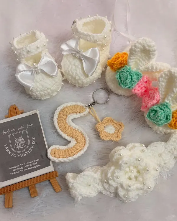 This custom crochet set was made with so much love for baby Sree Vaishnavi. It includes a pair of soft baby shoes, a matching floral hairband, and a personalized alphabet 'S' keychain, all crafted from premium, baby-safe yarn.