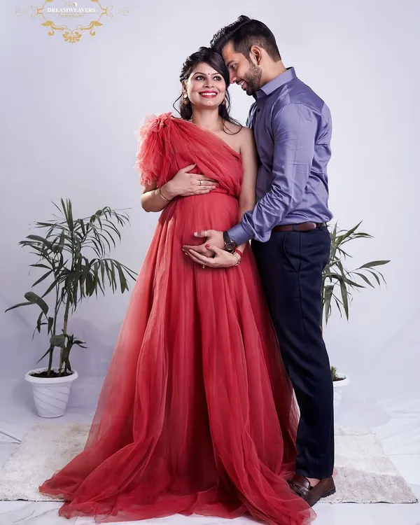 A beautiful portrait of an expecting couple, with the mother-to-be in a stunning red gown. We focus on capturing the connection and excitement you share as you wait for your little one.